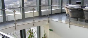 Garde-corps avec poteaux pinces à verre en fixation latérale